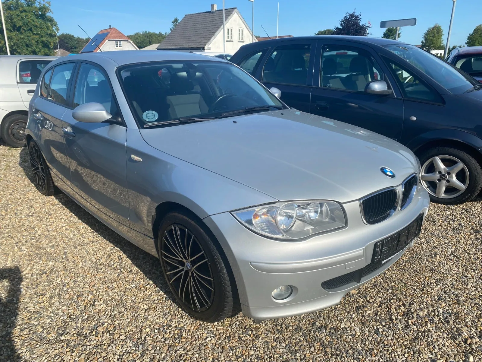 Sølvfarvet BMW 118i Advantage aut. 2,0 benzin, set skråt forfra